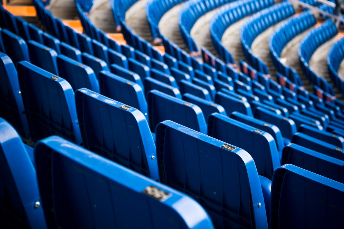 Empty blue bleachers in a stadium - Profound